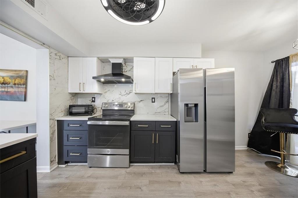 1039 Mariners Court Stone Mountain, GA 30083 - Photo 8 of 60 a kitchen with stainless steel appliances granite countertop a stove and a refrigerator