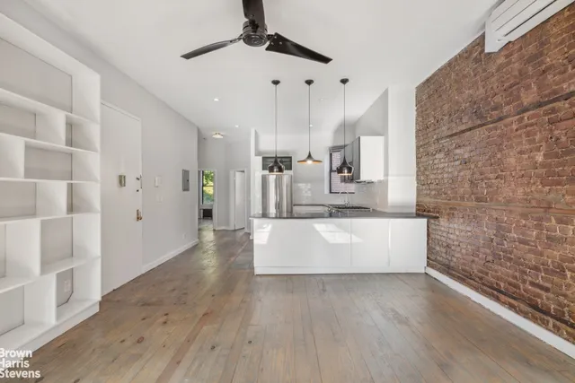 a large white kitchen with a large counter top appliances and cabinets