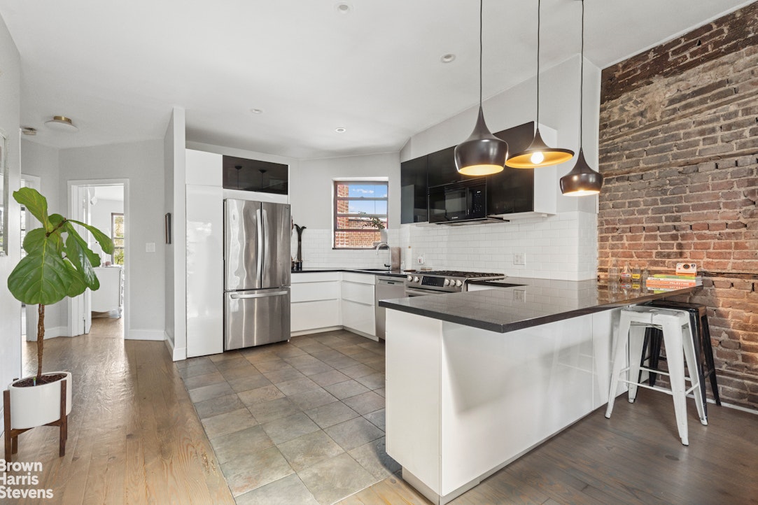 7 East 129th Street Manhattan, NY 10035 - Photo 18 of 24 a kitchen with stainless steel appliances a stove a sink a microwave a refrigerator and a stove
