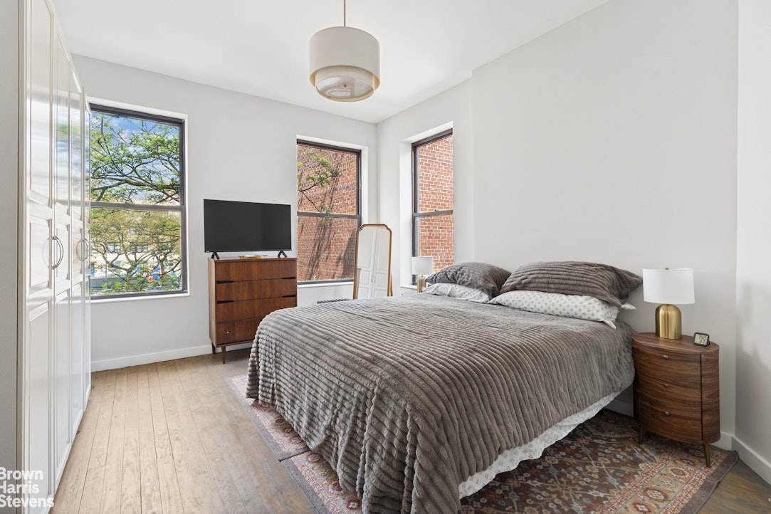 7 East 129th Street Manhattan, NY 10035 - Photo 19 of 24 a bedroom with a large bed and a flat tv screen