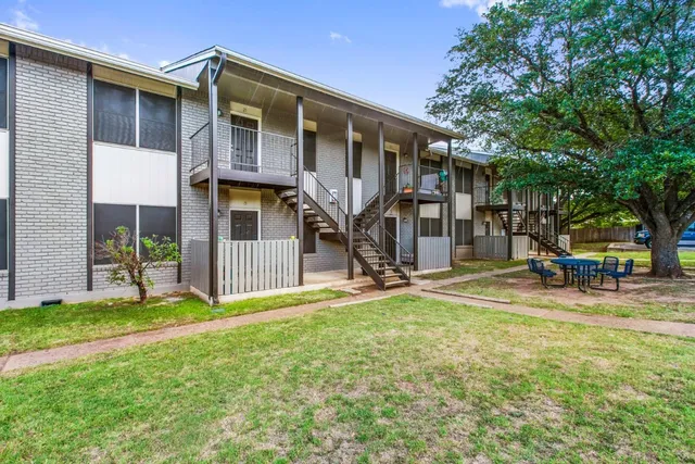 a view of a house with a yard and a patio