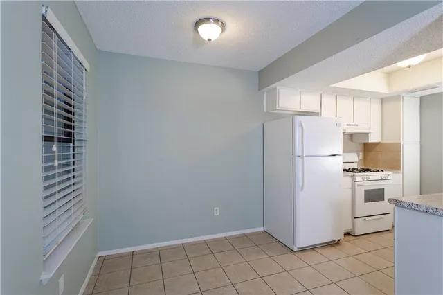 a kitchen with white cabinets and white appliances