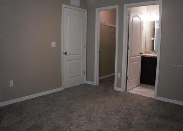 an empty room with closet and mirror