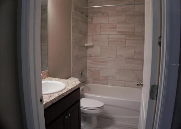 a bathroom with a granite countertop bathtub toilet and sink