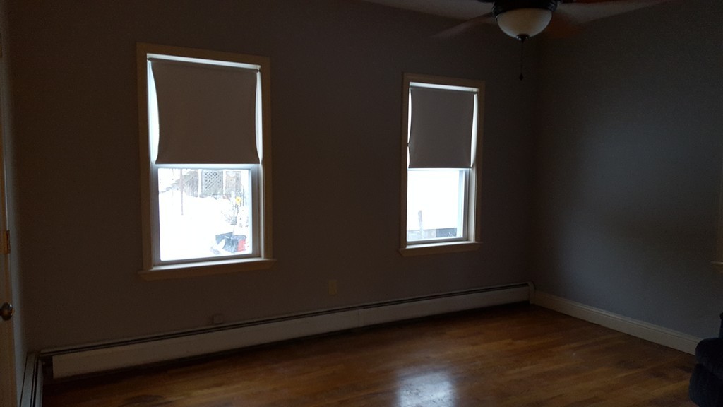634 2nd Street Fall River, MA 02721 - Photo 7 of 12 a view of an empty room with wooden floor and a window