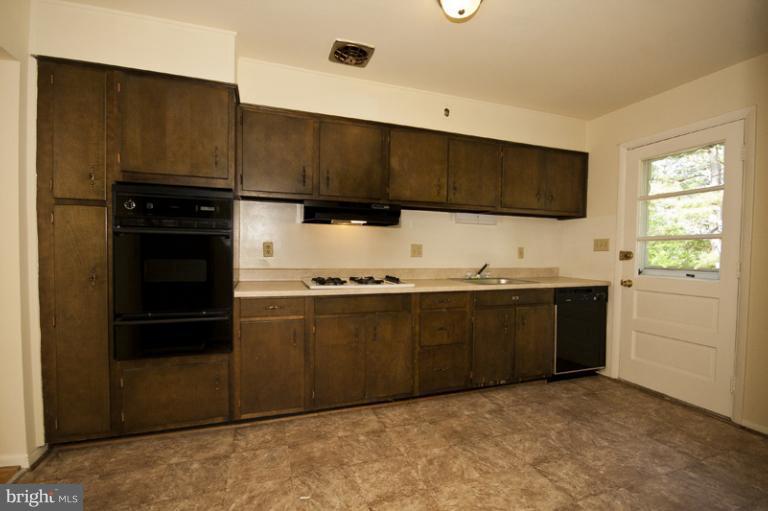 3912 Sybil Road Randallstown, MD 21133 - Photo 11 of 18 a kitchen with granite countertop a refrigerator and a stove top oven