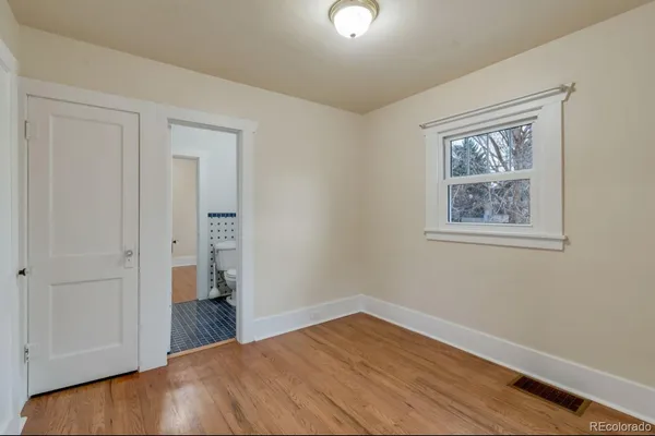 a view of empty room with wooden floor