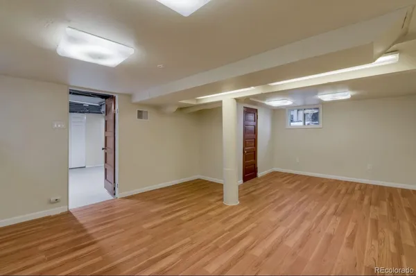 a view of an empty room with wooden floor