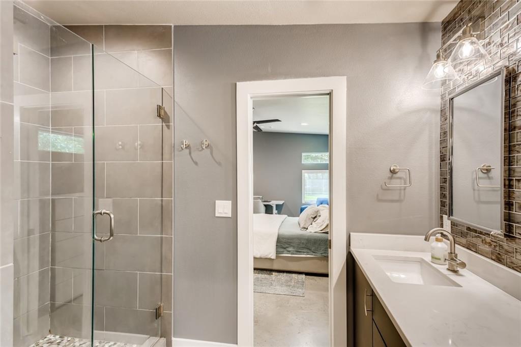 1142 Eleanor Street, Unit 2 Austin, TX 78721 - Photo 17 of 24 A sleek, contemporary bathroom features a spacious walk-in shower and modern vanity.