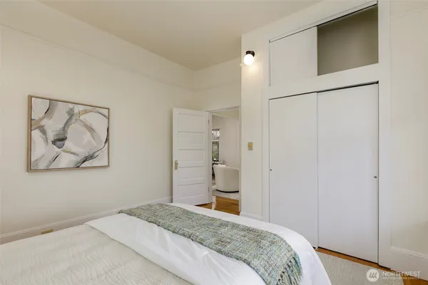a bedroom with a bed and a painting on the wall