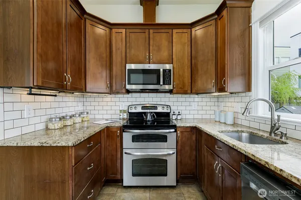 a kitchen with sink a microwave and cabinets