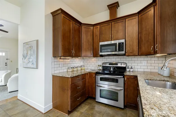 a kitchen with stainless steel appliances granite countertop a stove microwave and sink