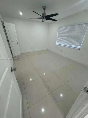 a view of a livingroom with a ceiling fan and window