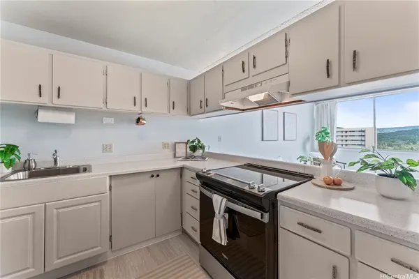 a kitchen with cabinets appliances a sink and a counter space