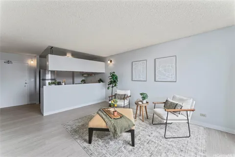 a living room with furniture and kitchen view