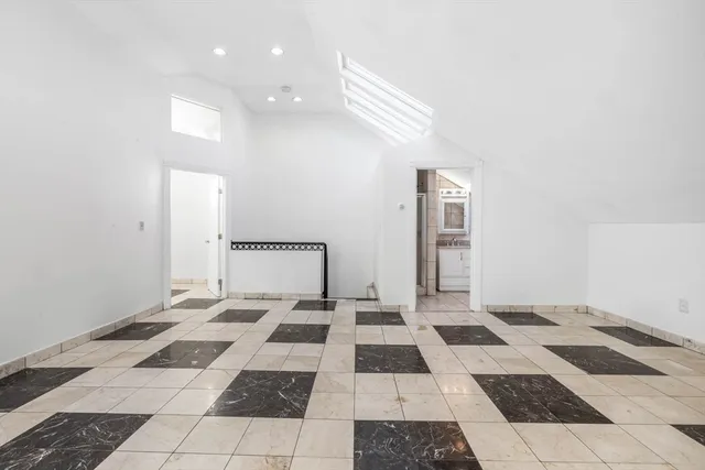 a spacious bedroom with a bed and a window