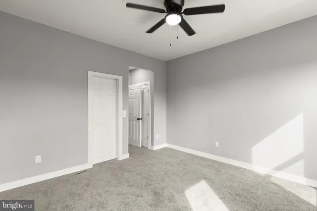 a view of a room with a projector and ceiling fan