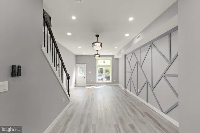 an entryway in a hall with a window and wooden floor