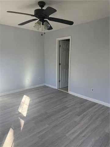 a view of empty room with wooden floor and window