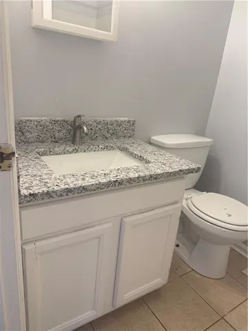 a bathroom with a granite countertop toilet and sink