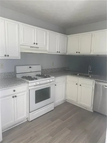 a kitchen with white cabinets and white appliances