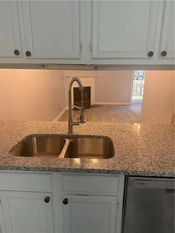 a view with granite countertop a sink and cabinets