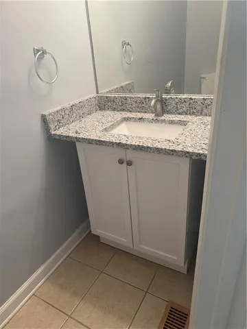 a bathroom with a granite countertop sink and a mirror