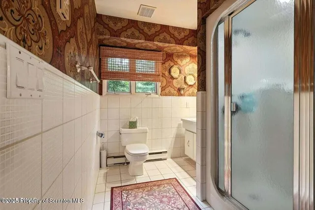 a bathroom with a toilet and a shower