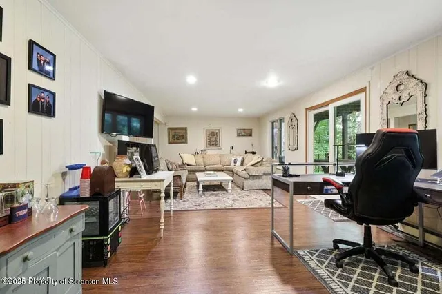 a living room with furniture flat screen tv and wooden floor