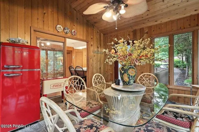 a view of a dining room with furniture a chandelier and large windows