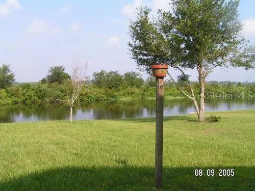 a lake view with a big yard and large trees