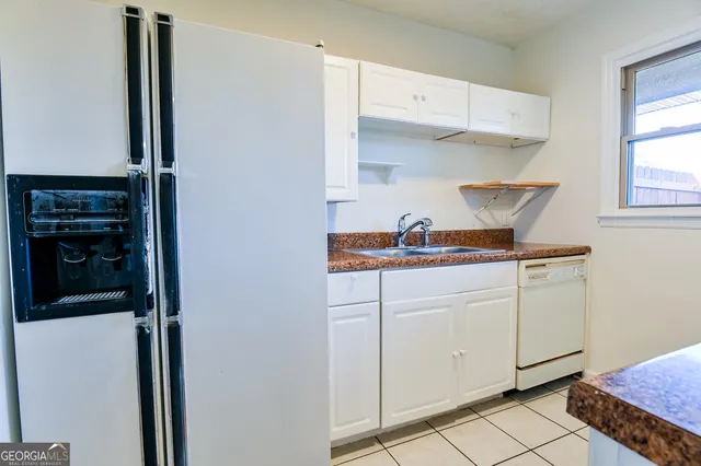 a kitchen with white cabinets and appliances