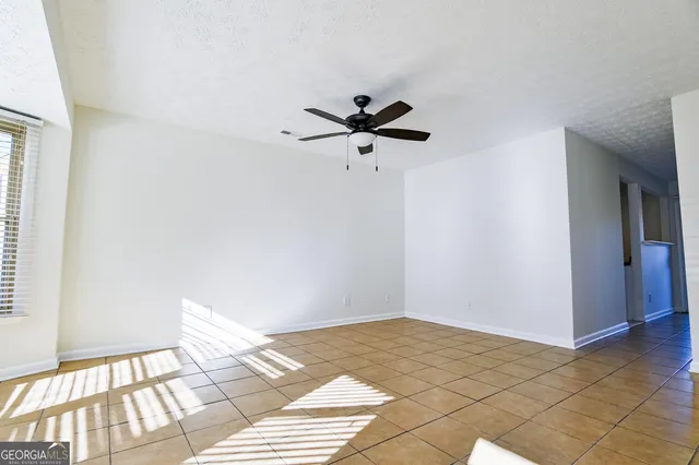 a view of a room with a ceiling fan and window