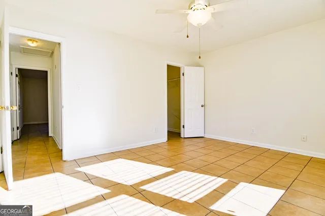a view of a room with wooden floor and ceiling fan