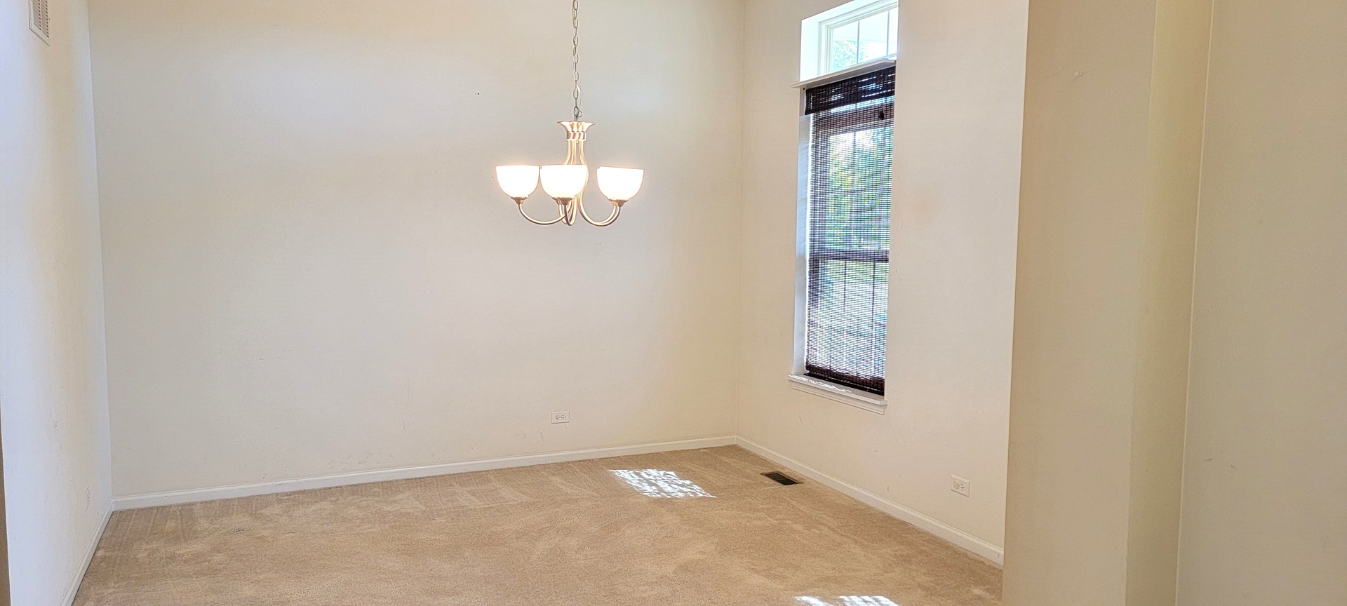 264 Monument Road Elgin, IL 60124 - Photo 4 of 18 an empty room with chandelier fan and windows