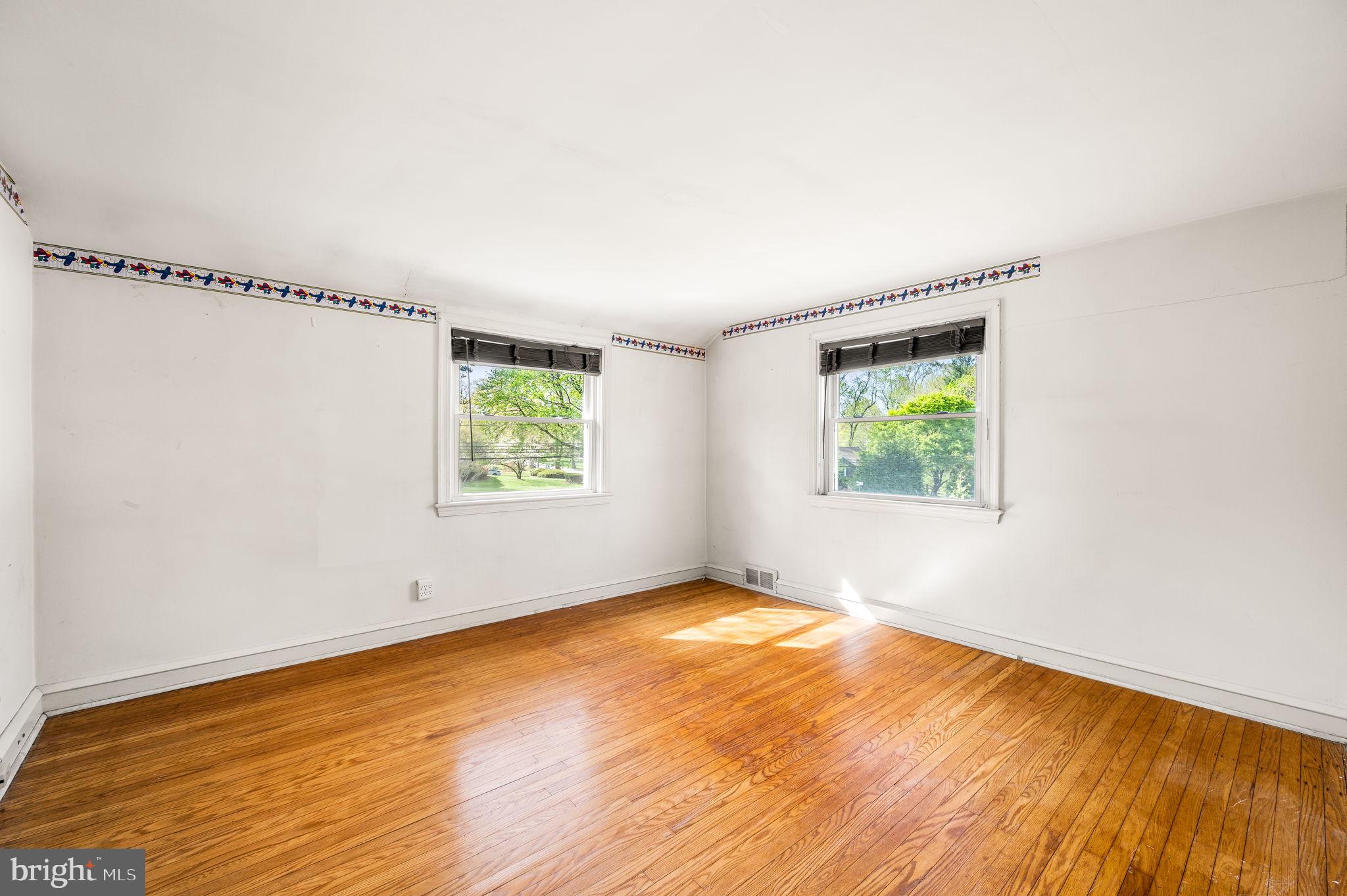 101 East Rose Valley Road Wallingford, PA 19086 - Photo 24 of 38 a view of an empty room with wooden floor and a window