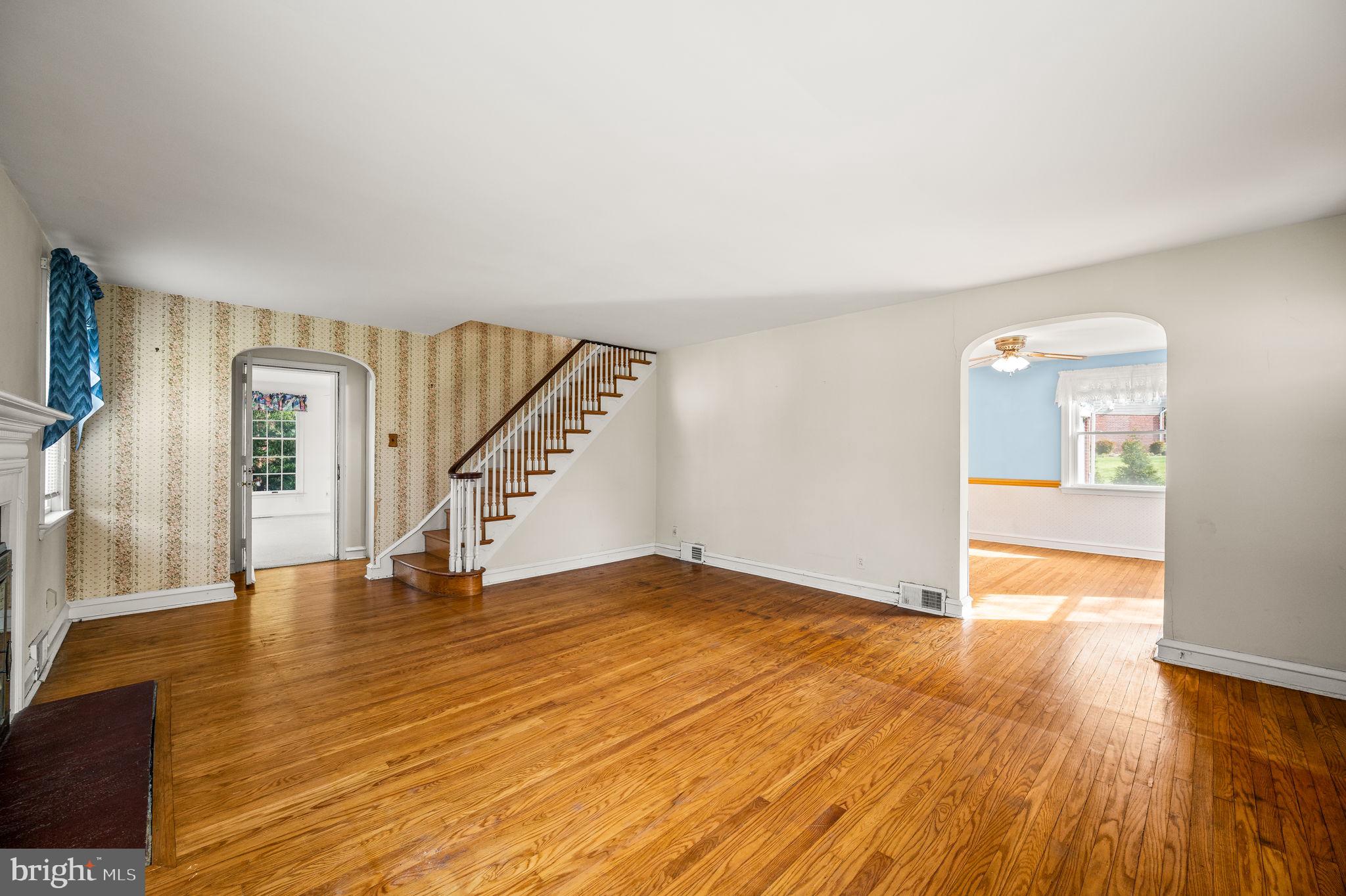 101 East Rose Valley Road Wallingford, PA 19086 - Photo 6 of 38 a view of an empty room with wooden floor and a kitchen