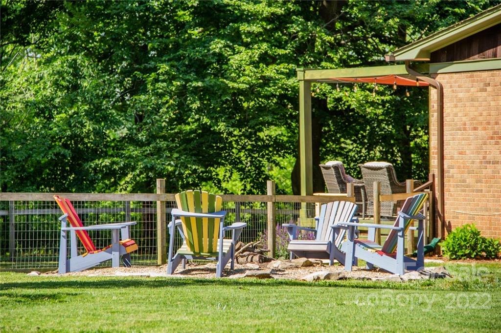 171 Orchard Road Statesville, NC 28677 - Photo 8 of 46 a view of a backyard with a slide trees and wooden fence