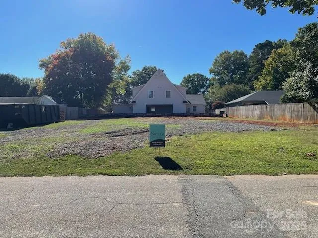 a front view of house with yard and trees in the background