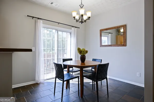 a dining room with furniture a chandelier and wooden floor