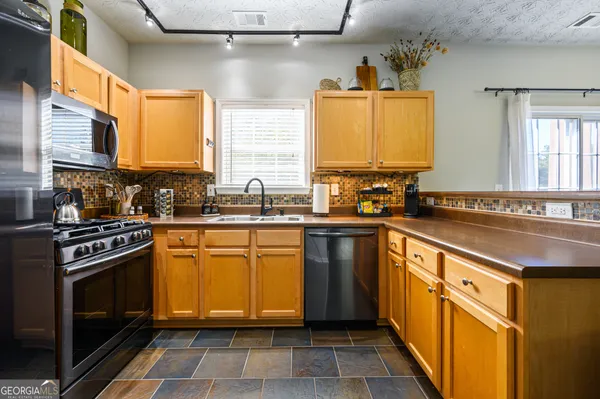 a kitchen with stainless steel appliances a sink stove and cabinets