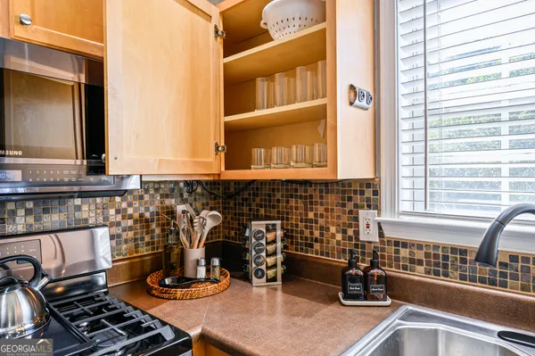 a kitchen with a stove a sink and a microwave