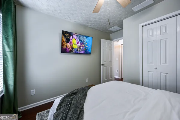 a bedroom with a bed and a painting on the wall