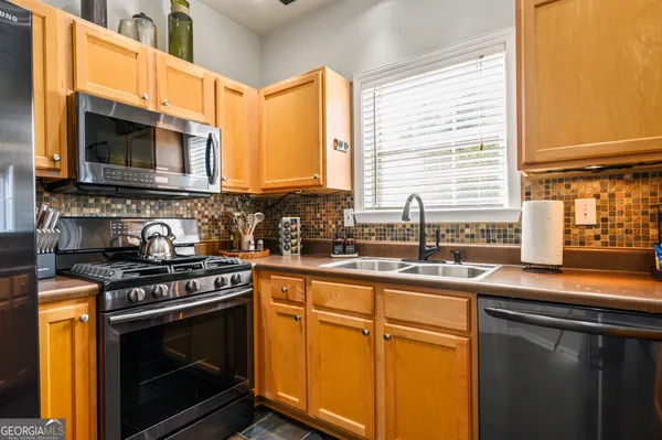 a kitchen with stainless steel appliances a stove sink and microwave