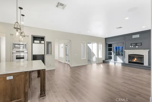a open kitchen with refrigerator a fireplace and wooden floor