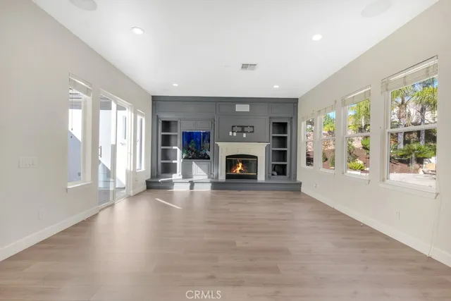 an empty room with windows and fireplace
