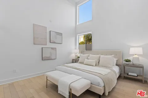 a bedroom with a bed and painting on the wall