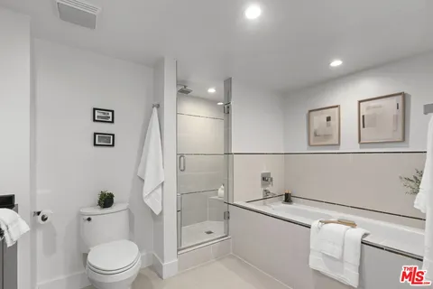 a spacious bathroom with a granite countertop sink a toilet and shower
