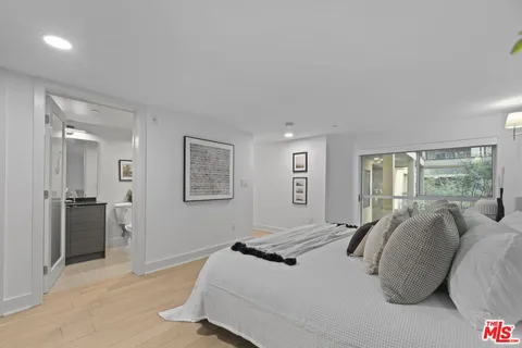 a bedroom with a bed and a large mirror