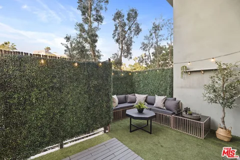 a view of a roof deck with couches and wooden floor